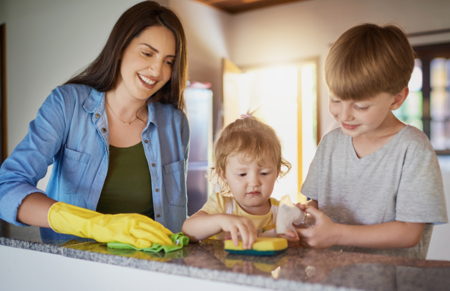 mother teaching kids how to clean the counter table with sponge and detergent
