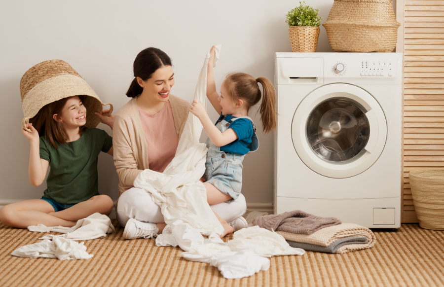 mother and little girls having fun while doing the laundry