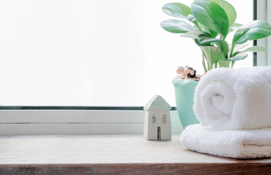 clean towels with houseplant on wooden counter table in bathroom