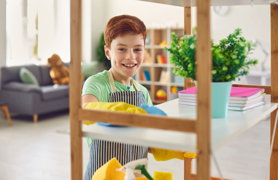 cute kid in rubber gloves cleaning shelves with rag at home